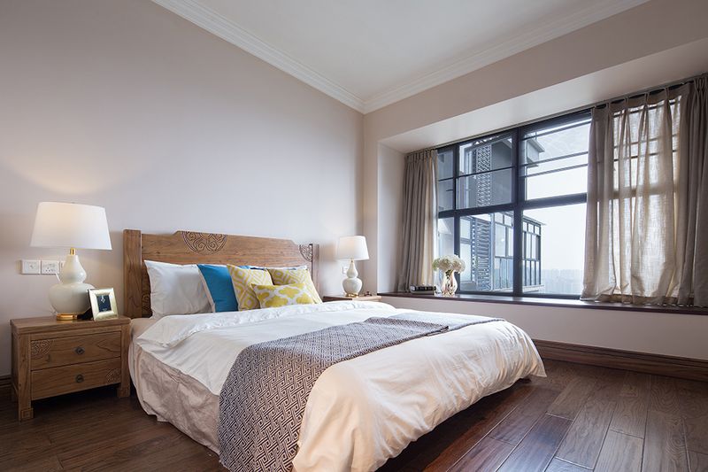 简单的木质大床沿袭着全屋的风格，床头柜带着中国风特色的台灯可以称之为点睛之笔。