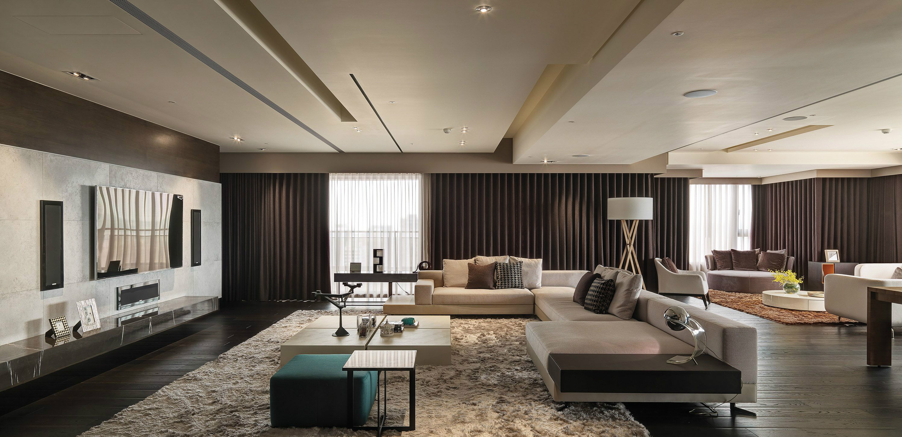 客厅设计以现代风格为主，米白色沙发和地毯将功能区划分的很清楚。