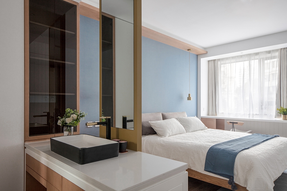 主卧套房设计，蓝色背景墙与木床搭配，增添一抹别出心裁的静谧感。