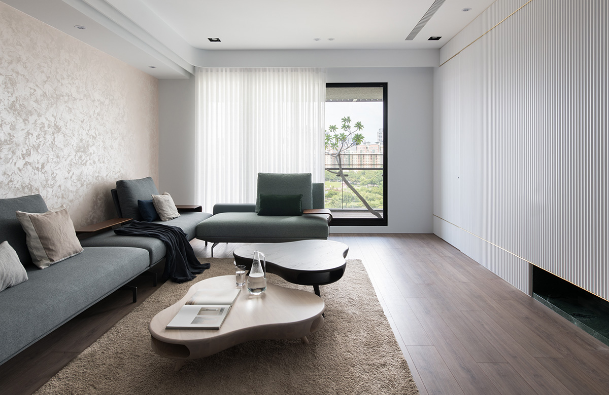 客厅以浅色为基调,沙发精简设计,背景墙使用壁纸铺贴,格局十分大气