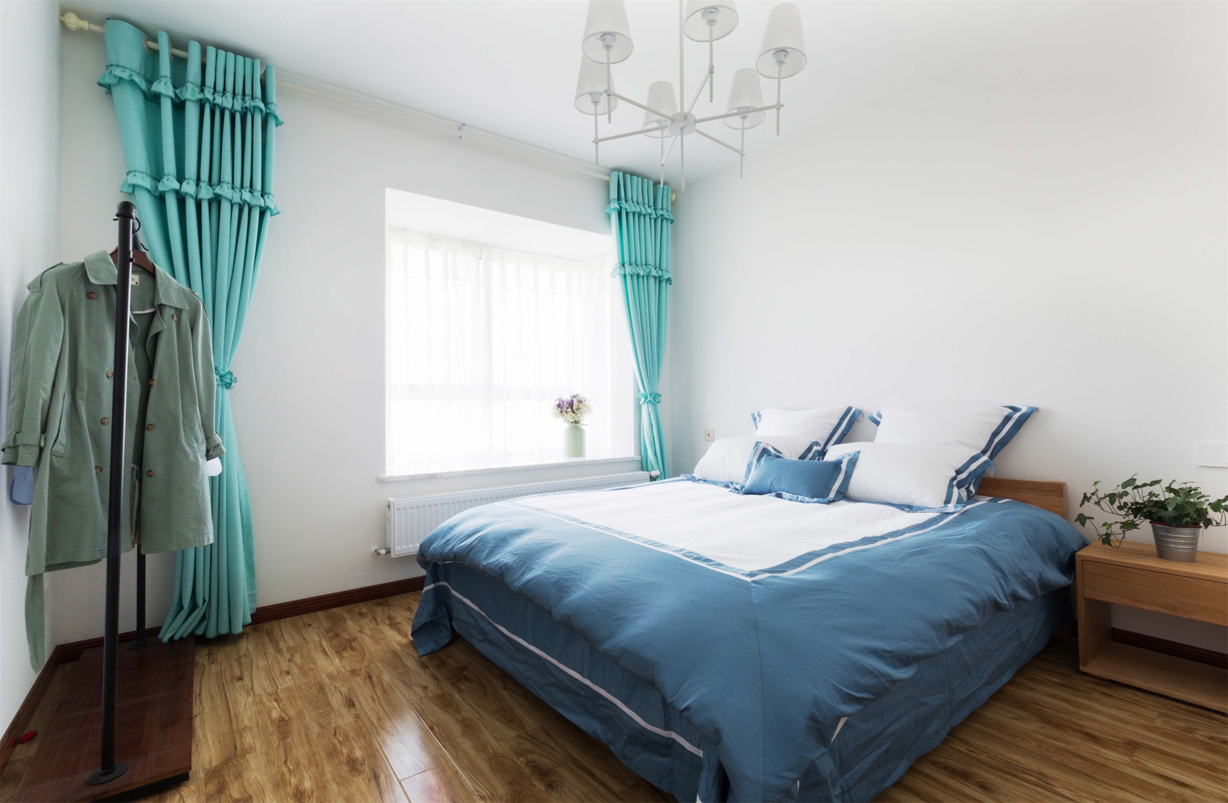 主卧整体以白色为主，设计师用精心挑选的蓝色床品装饰提升浪漫感。