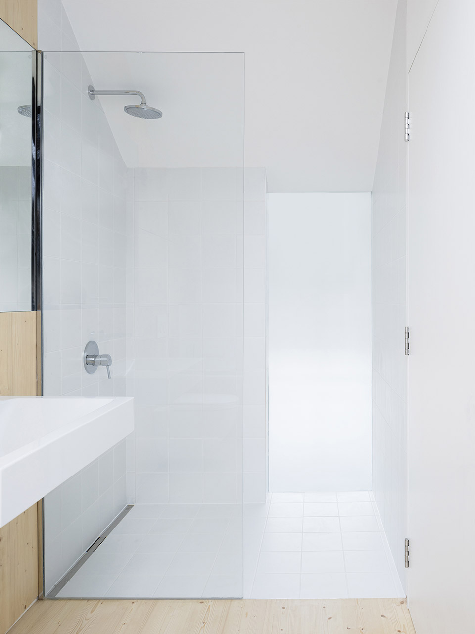卫浴间的另一侧设置了淋浴房，白色立面下玻璃带来光感，令空间更加明亮。