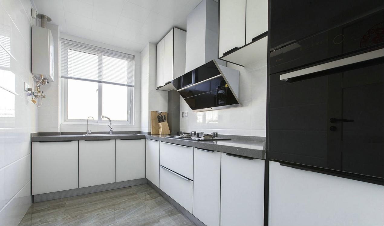 厨房以白色为主，融入了少量黑色厨电加以点缀，避免单调。厨房根据实际情况安装了吊橱，增加收纳空间。