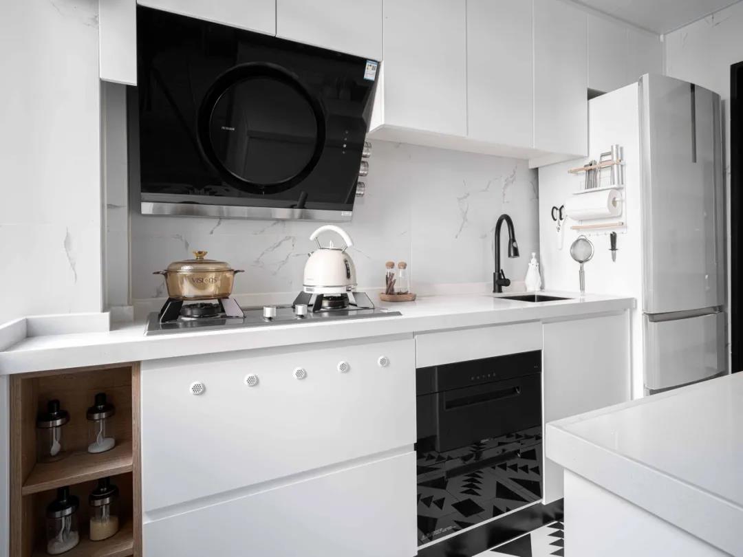 白色橱柜搭配大理石材质背景墙，宁静质朴的格调扑面而来，彰显出烹饪空间的时尚感。