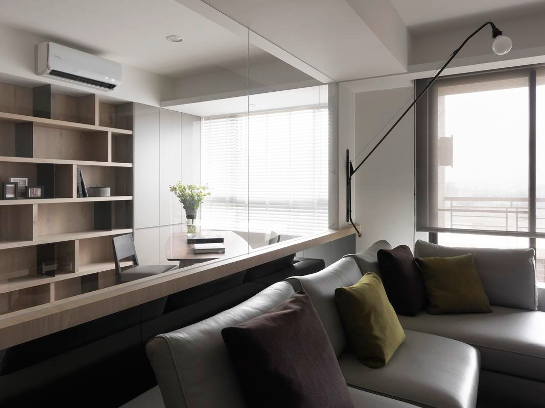 灰色皮质沙发作为空间隔断，合理划分了工作区和休闲区，整体配色淡暖温馨。