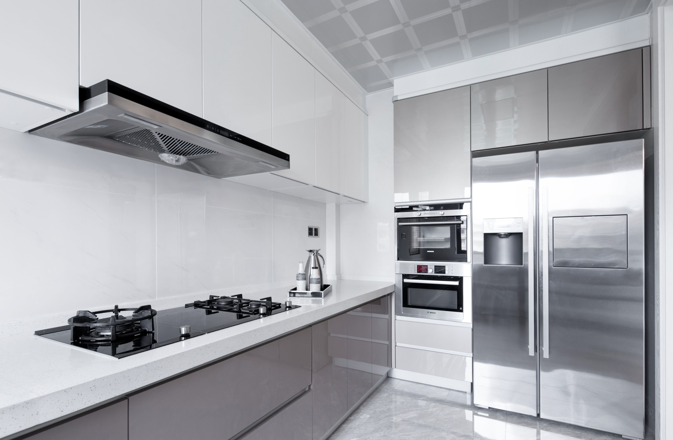 厨房配色柔和沉稳，定制的背景收纳刚好能将冰箱嵌入放置，提升了空间的使用率。