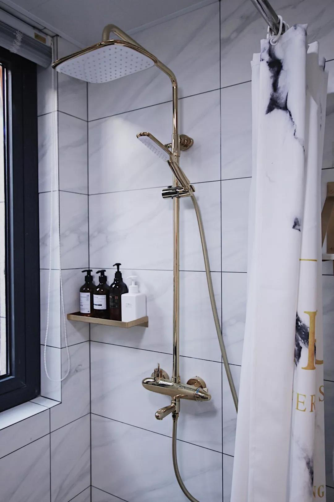 淋浴房使用浴帘做干湿分离，看起来更加美观和惬意，搁板提升空间收纳能力。