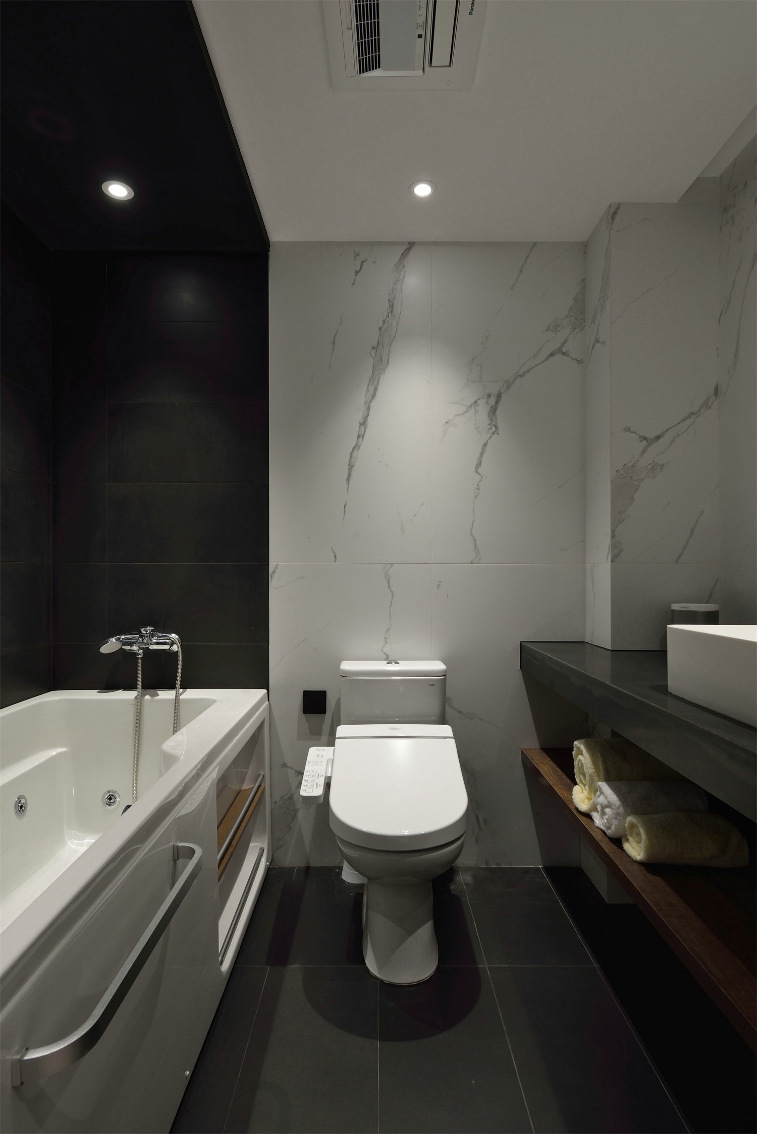 卫生间使用大理石作为背景墙，搭配黑色地砖，演绎出低调素雅的既视观感。