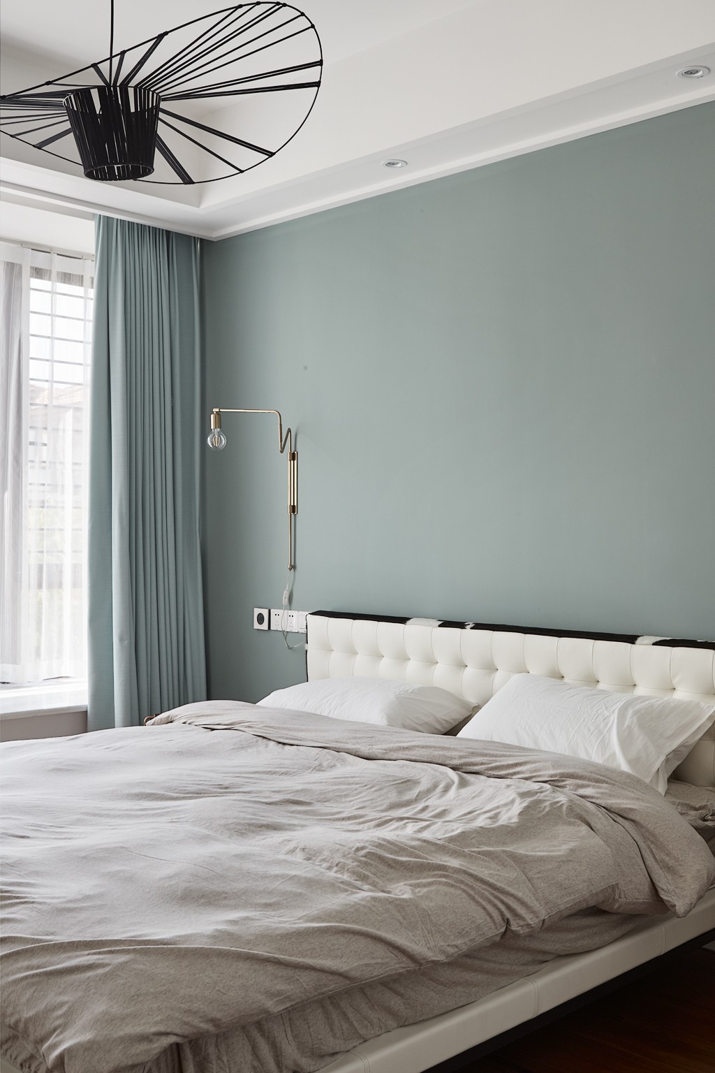 侧卧设计简单，果木绿背景墙与浅色床品让卧室空间显得舒适而温情。