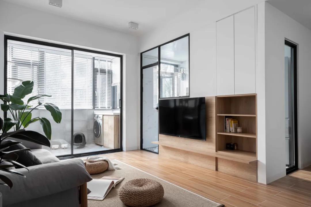 电视机背景墙以原木色和白色为主，给空间提供了温暖与宁静并存的平衡。