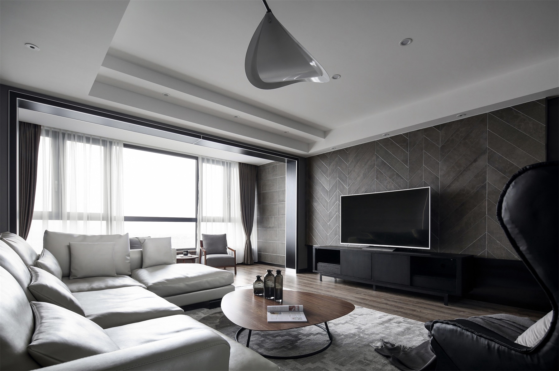 客厅面积空间宽敞，空间使用暗色系打造，局部亮色沙发点缀，彰显现代家居质感。