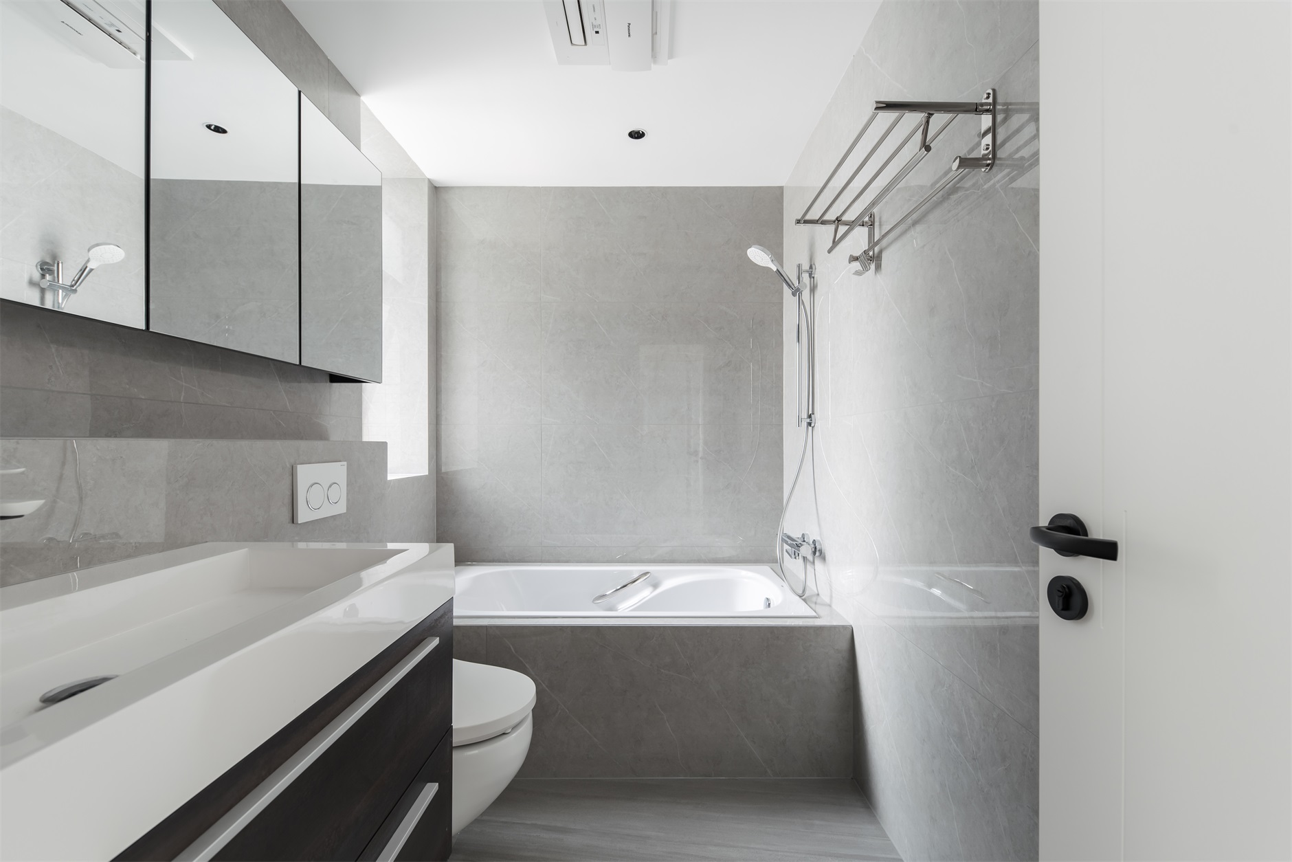 卫生间以灰色为主基调，浴缸、坐便器、洗手池动线划分较好，使空间干净整洁。 