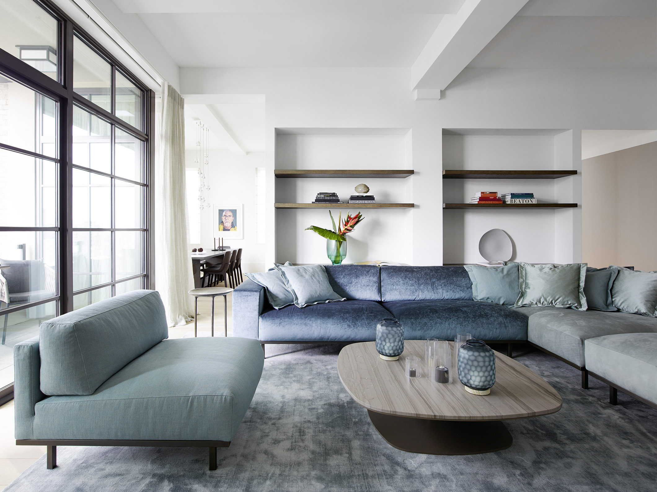 蓝色沙发表现出主人的浪漫情怀，背景展示架又使整个客厅空间富有层次。