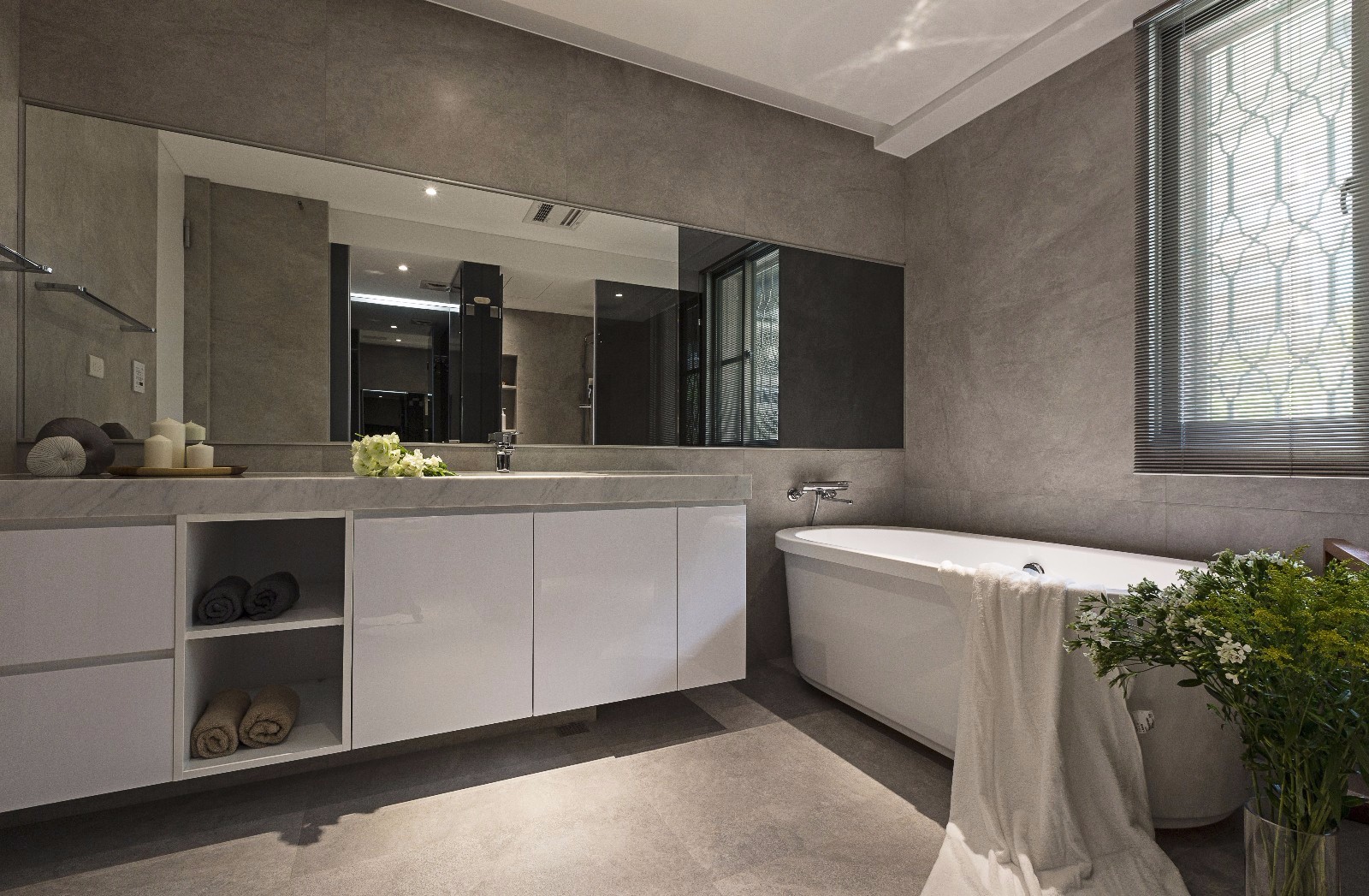 卫浴空间以米色为基调，洗手台设计成条状，家具线条流畅，空间时尚而明亮。