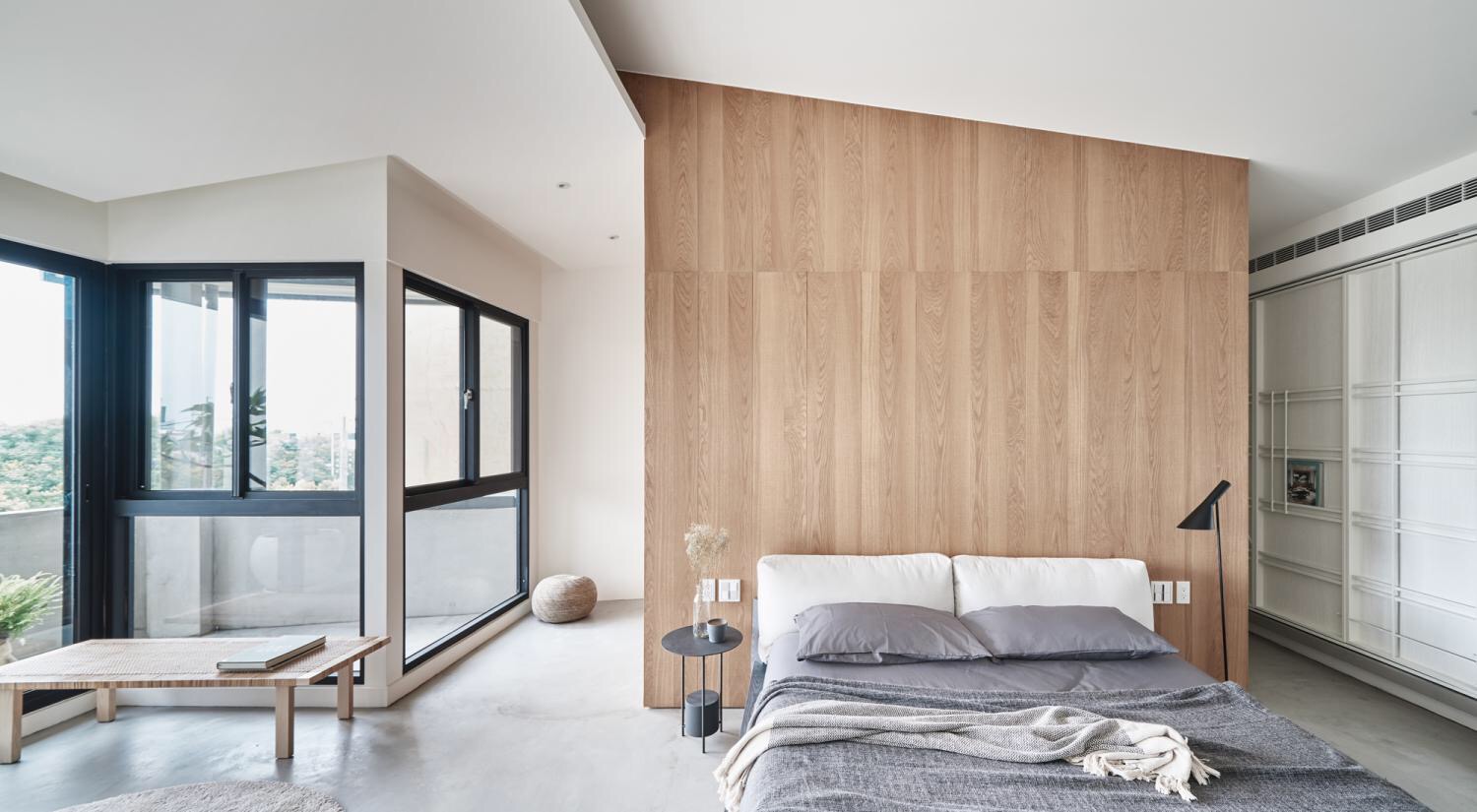 木质的背景墙使主卧平实而自然，搭配白色床头和灰色床品，层次感十足。