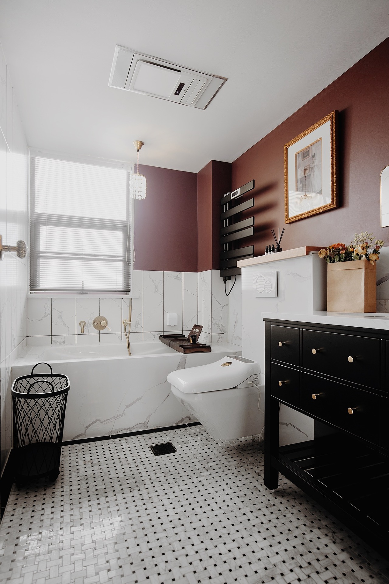 砖红色背景墙与黑色洗手柜凸显复古气息，浴缸营造出舒适的沐浴氛围。