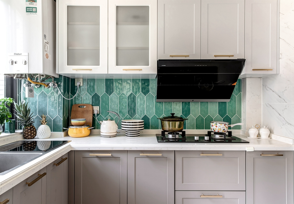 厨房空间选用碧色的瓷砖装饰墙面，营造出清新自然感，搭配以白色橱柜，大气优雅之感呼之欲出。