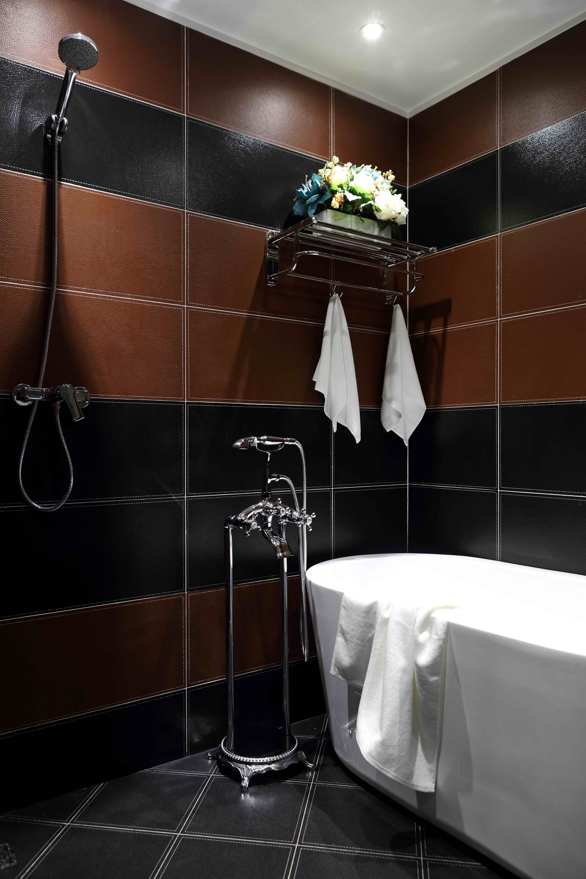 在砖红色与黑色搭配下，空间沉稳雅致，室内兼具浴缸与淋浴，体现主人对生活的追求。