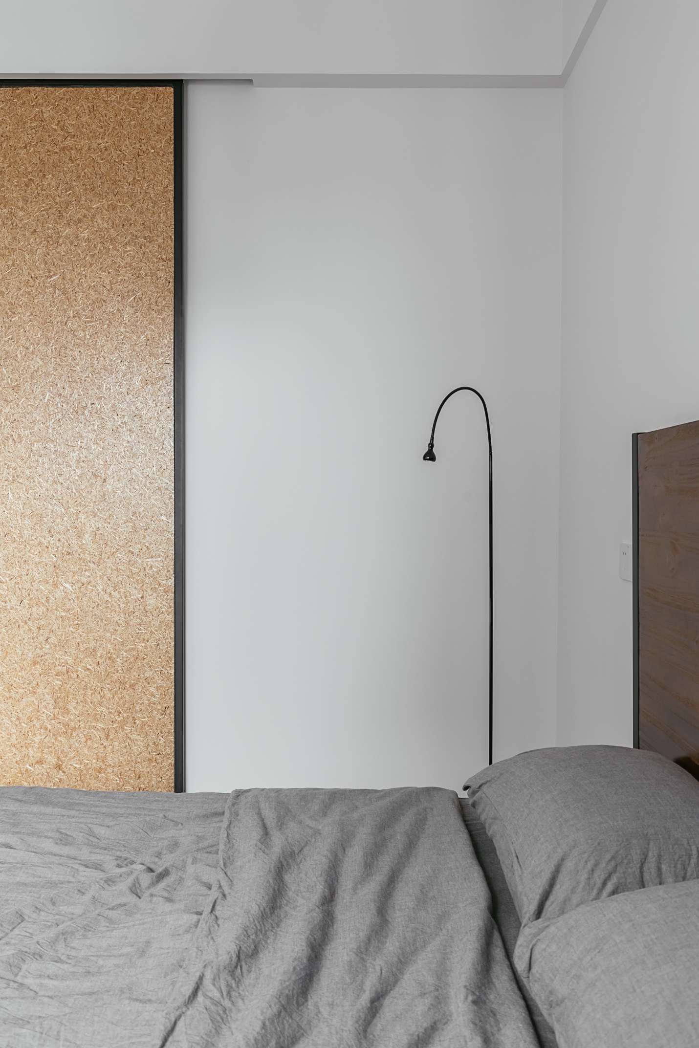 主卧采用灰色、白色和木色相糅合，造出一个温暖舒适的卧室空间。