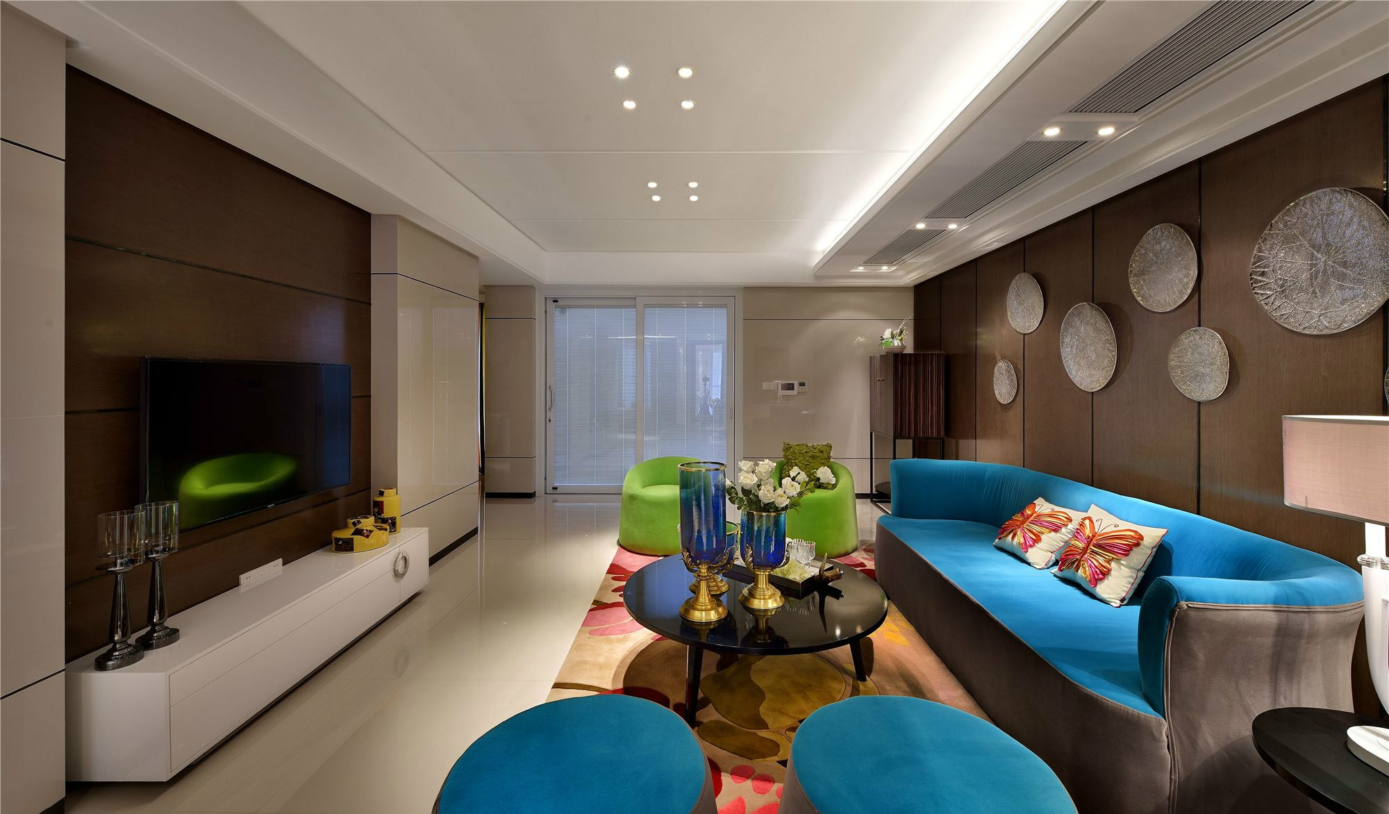 客厅装饰以简约的色块为主，沙发采用明快清新的蓝绿色设计，带来时尚的观感体验。