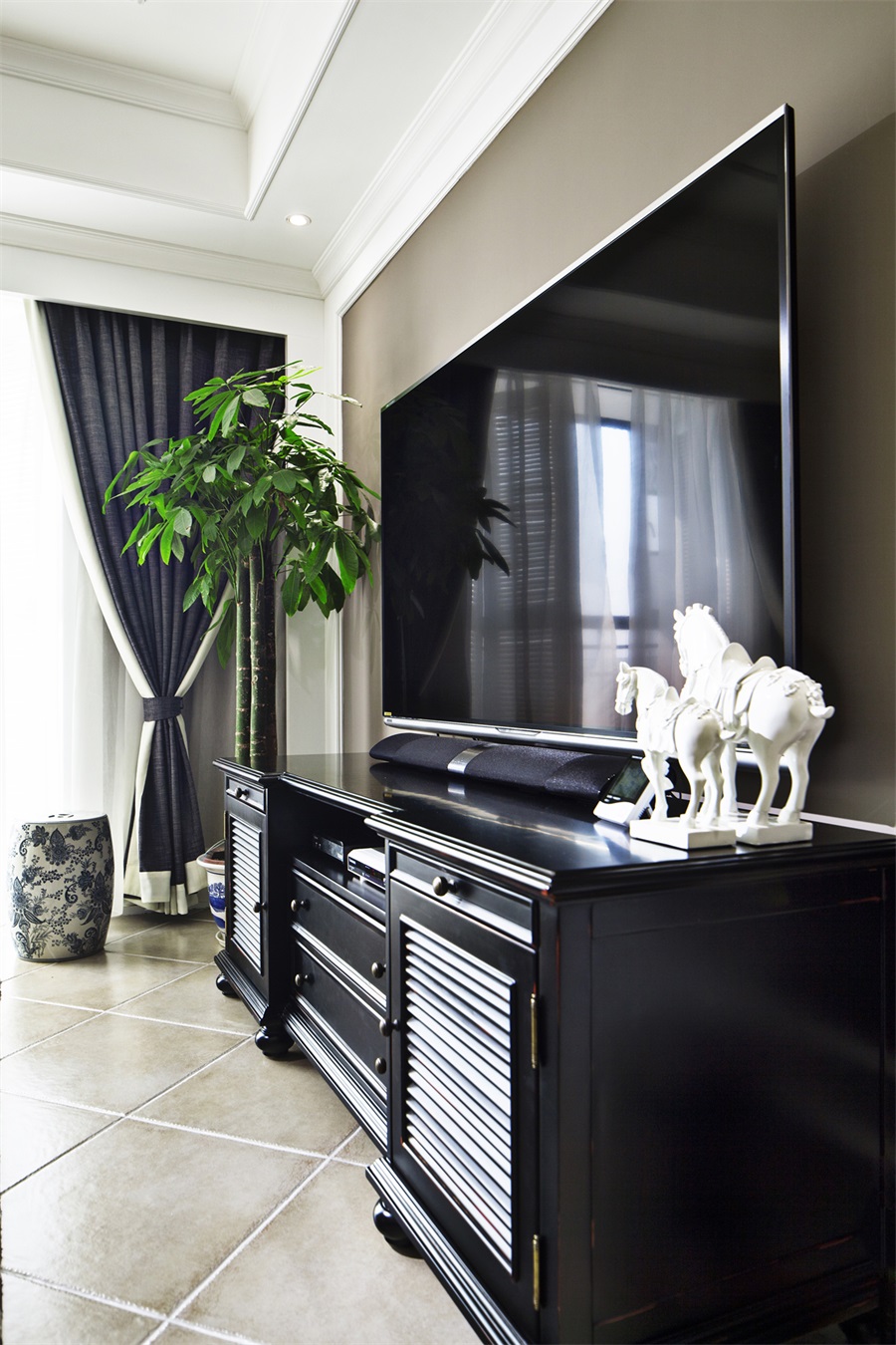 黑色电视机柜带来沉重的感觉，局部使用白色摆件体提色，更具欧式复古风味。
