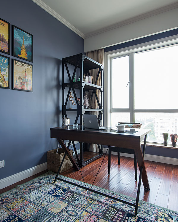 书房结构紧凑，蓝色背景墙凸显静谧的办公氛围，局部亮色装饰画提升活跃感。