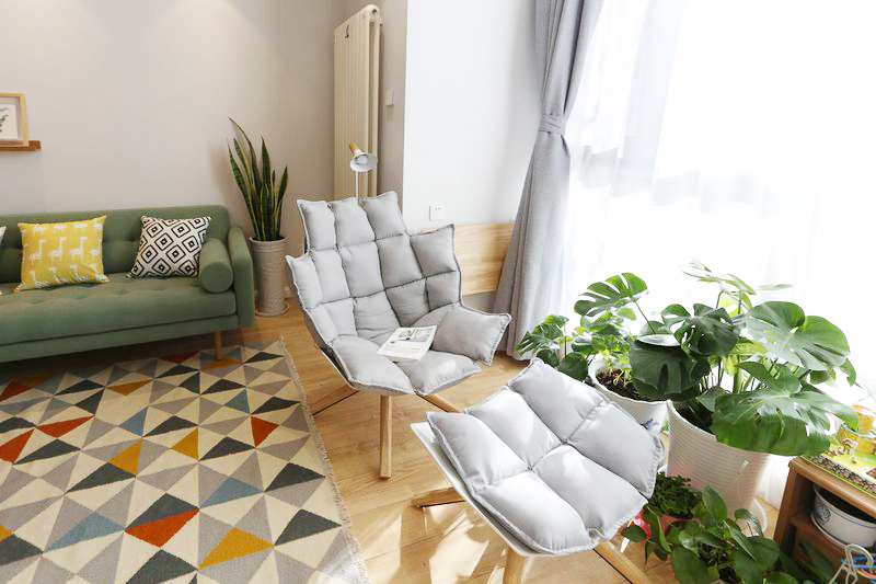 灰色椅子，在床边，和绿植在一起，一片慵懒，安详的画面。