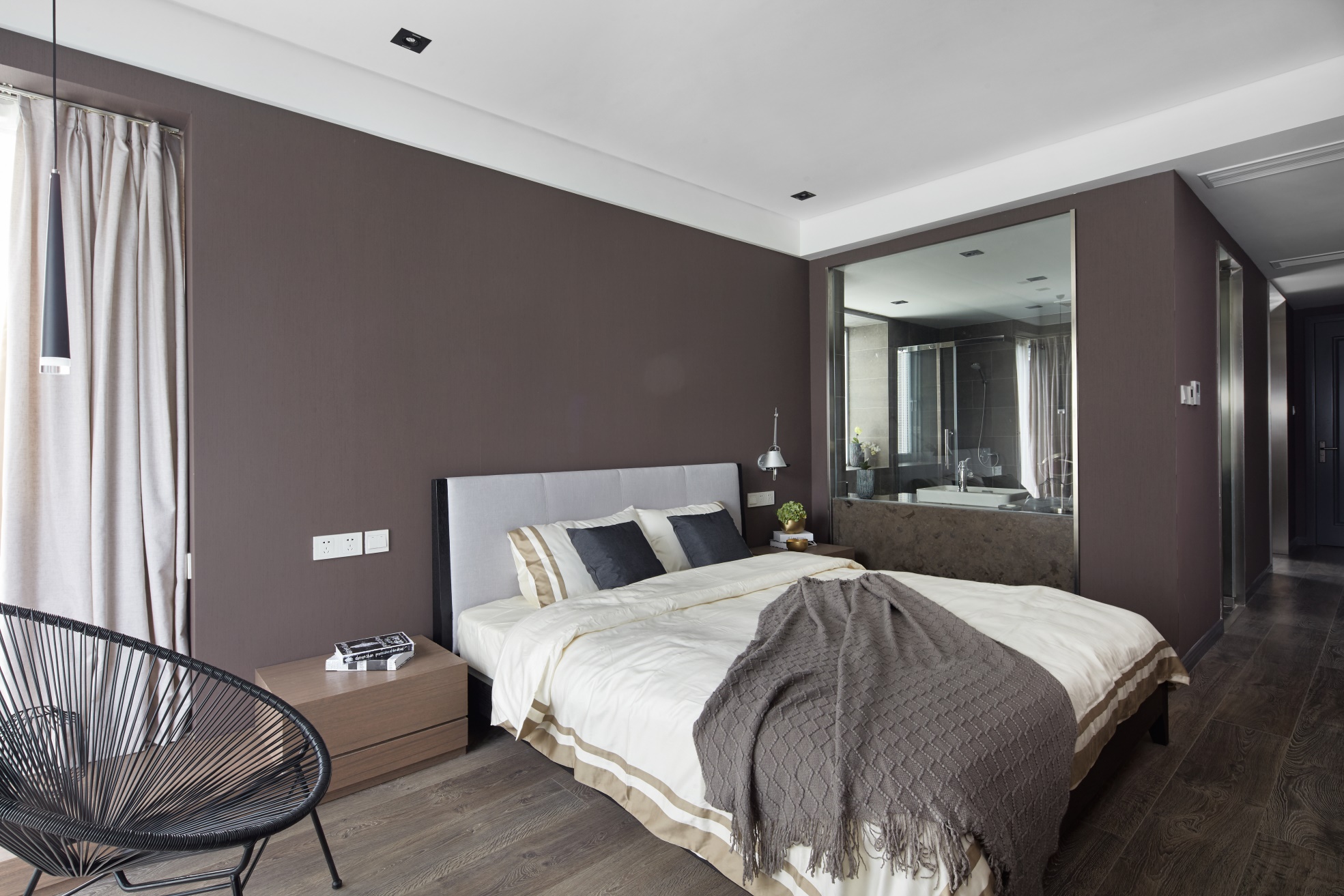 静谧温润的咖色系营造出雅致的卧室氛围，背景墙设计简约高级，明镜衬托华而不俗。