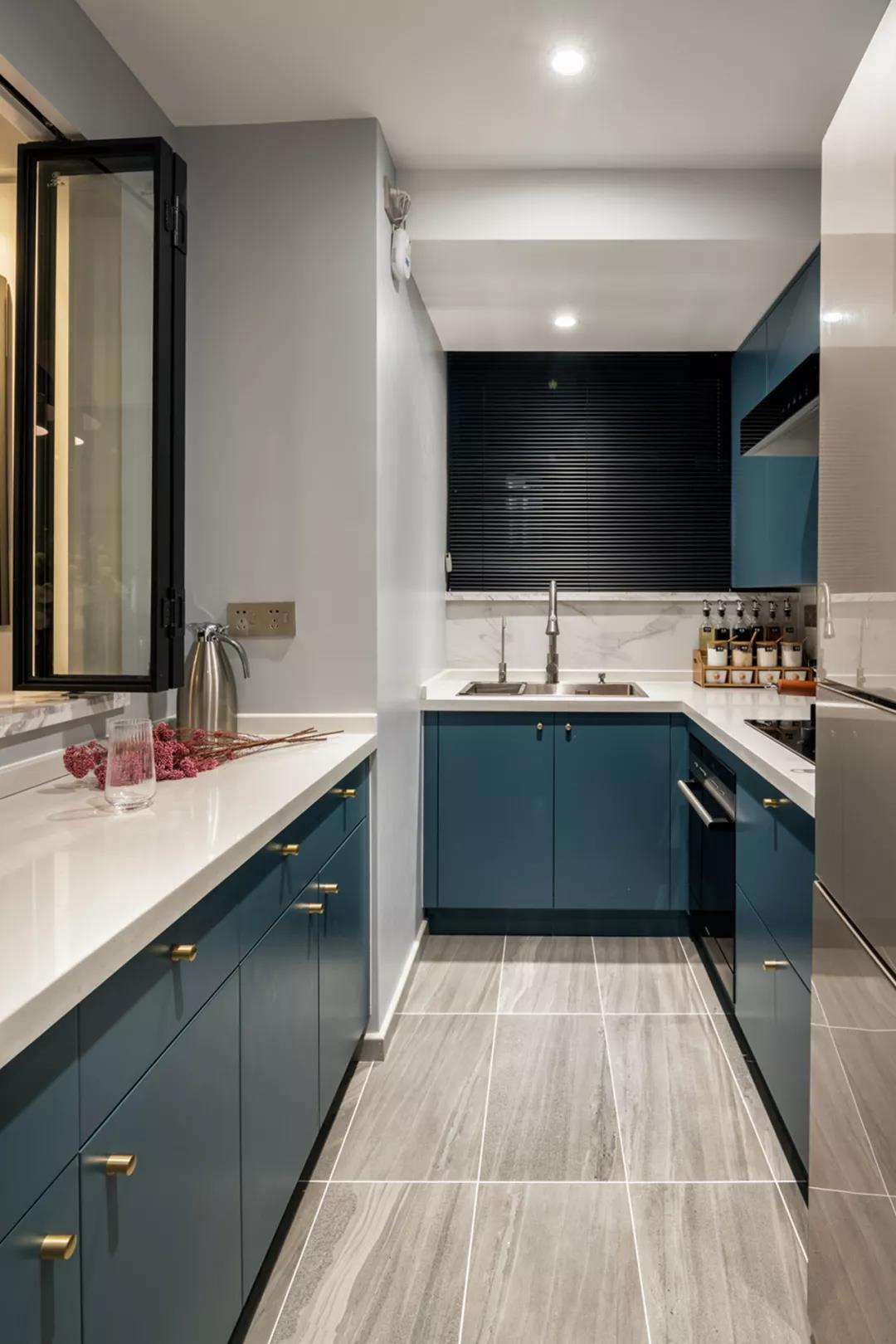 蓝色橱柜设计精致大方，搭配白色工作台，使室内空间环境氛围营造出独特的品味。