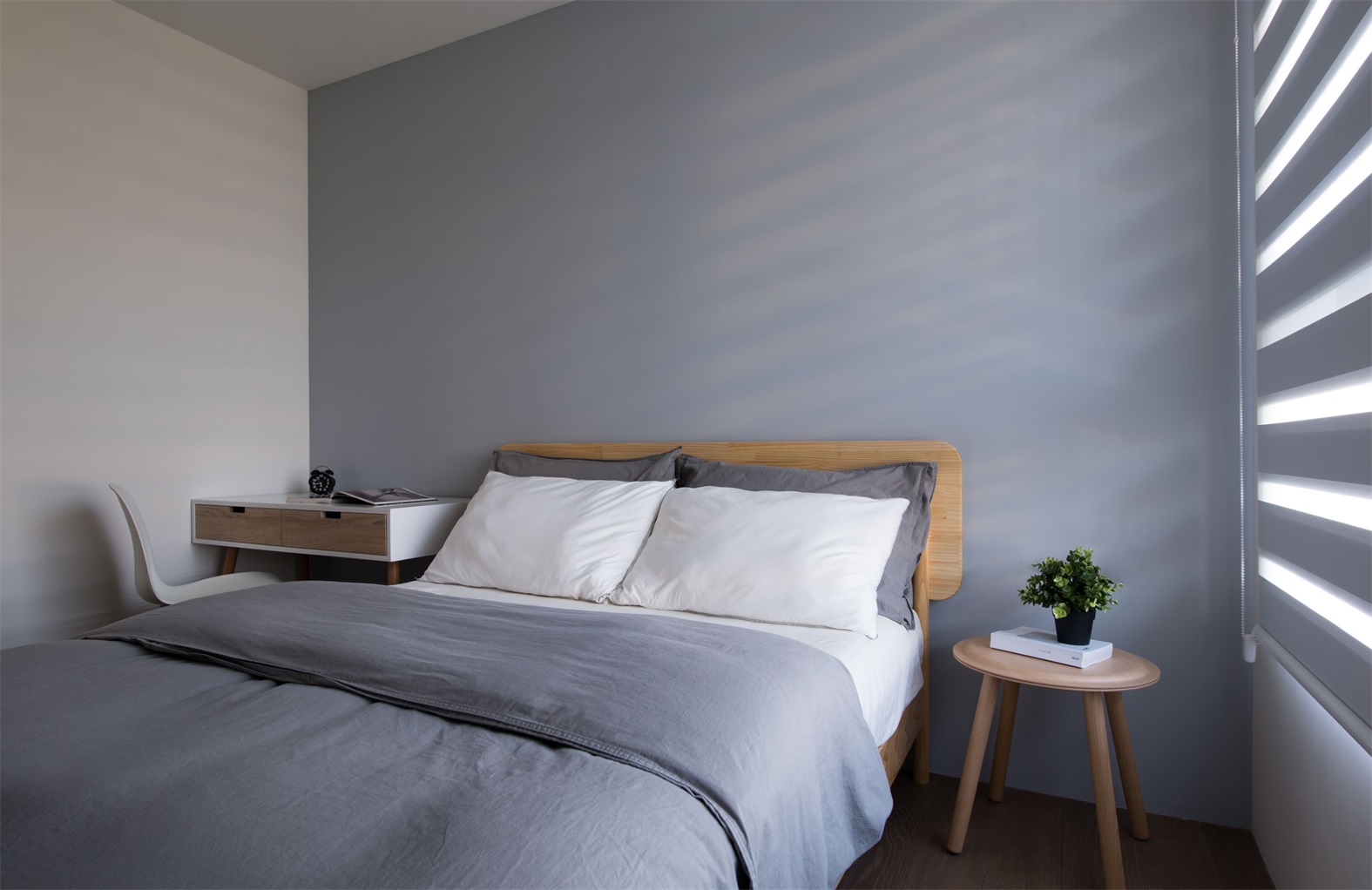 侧卧空间以灰色为基调，白色床品成为空间点缀，简洁俐落之感油然而生。