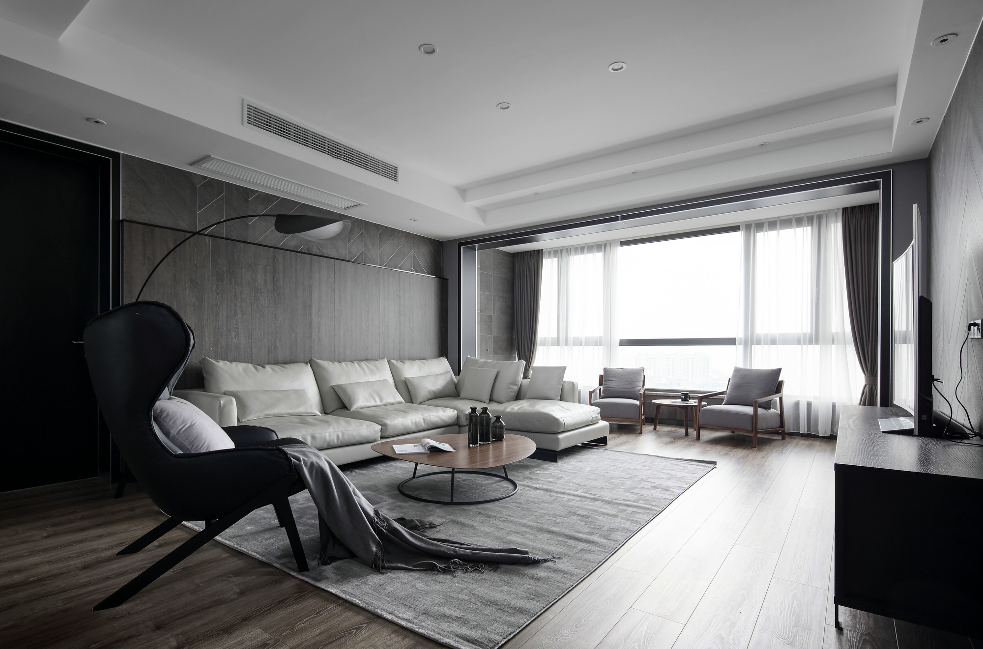 客厅以黑白灰为主调，展现了一个宁静空灵的世界，体现出现代风格的大气与干练。