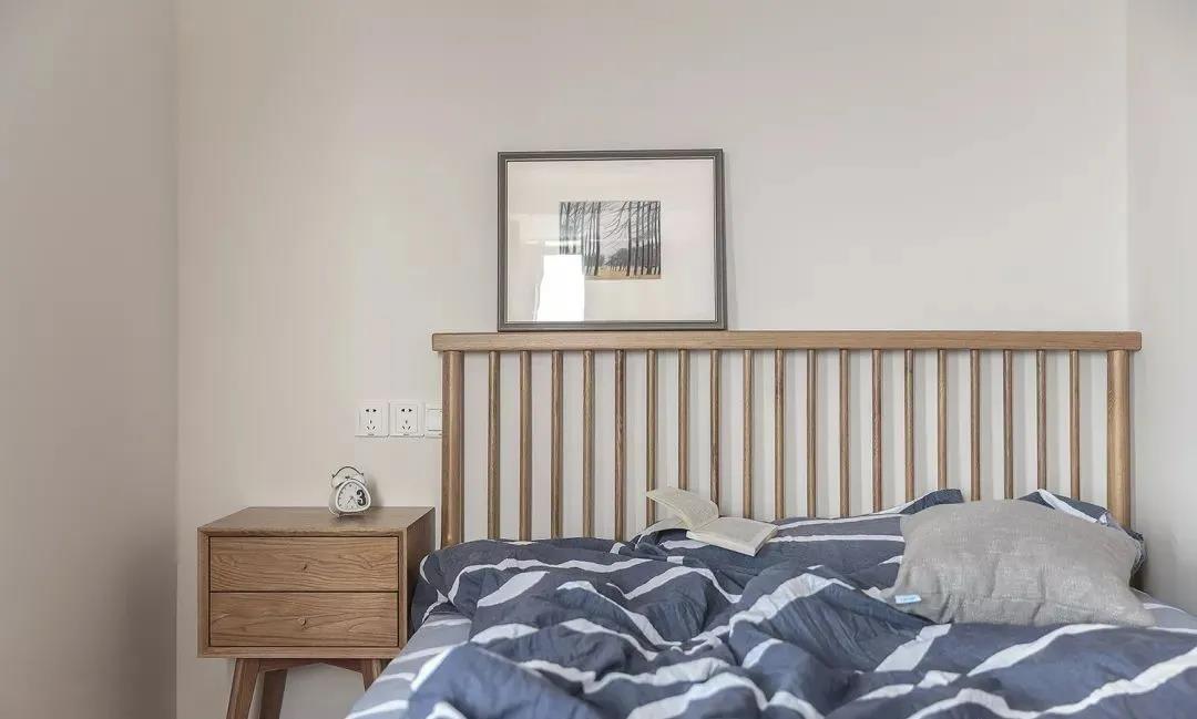 卧室仍旧以白色和木色相搭配，床品使用素朴颜色打造，给予最温馨的感受。