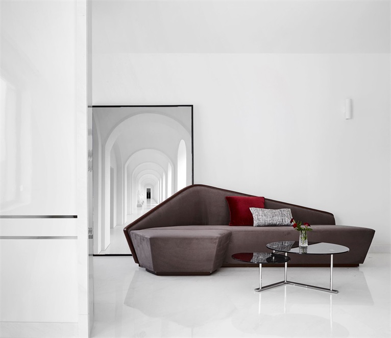 客厅无主灯无吊顶设计，呈现出简洁明快的空间氛围，沙发造型具有设计感。