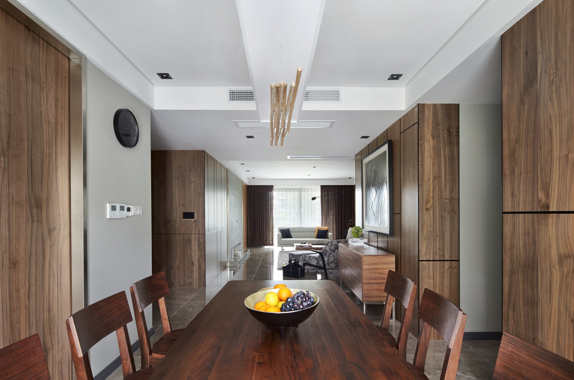 餐厅与客厅相连，沿用木质基调，餐桌椅、背景墙木色邻近，呈现出自然雅致的用餐环境。