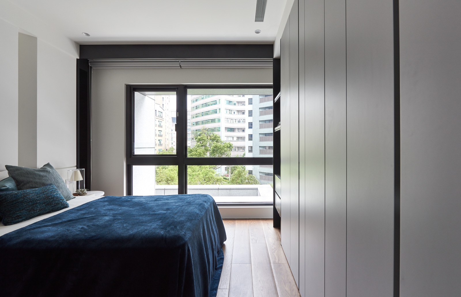 主卧设计清新简净，嵌入式衣柜提升了空间的利用率，蓝色床品品质感高。