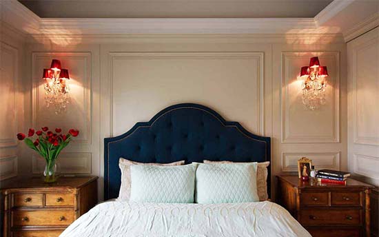 次卧背景使用壁灯进行对称设计，营造出独特的光影之美，蓝色欧式床头贵气十足。