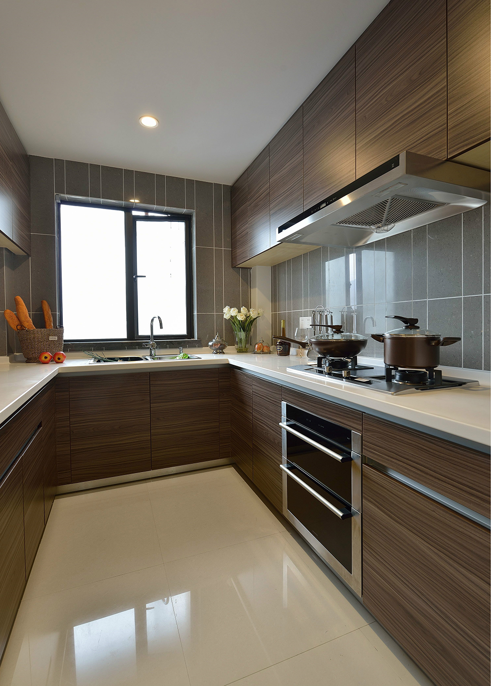 厨房空间定做了木质橱柜，在浅咖色背景墙中展现出沉稳、深邃的气质。