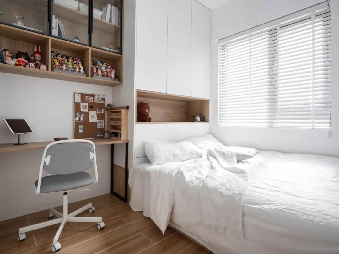 榻榻米衣柜使整个次卧空间氛围更加协调温柔，白色与木质色调的搭配温馨而高级。