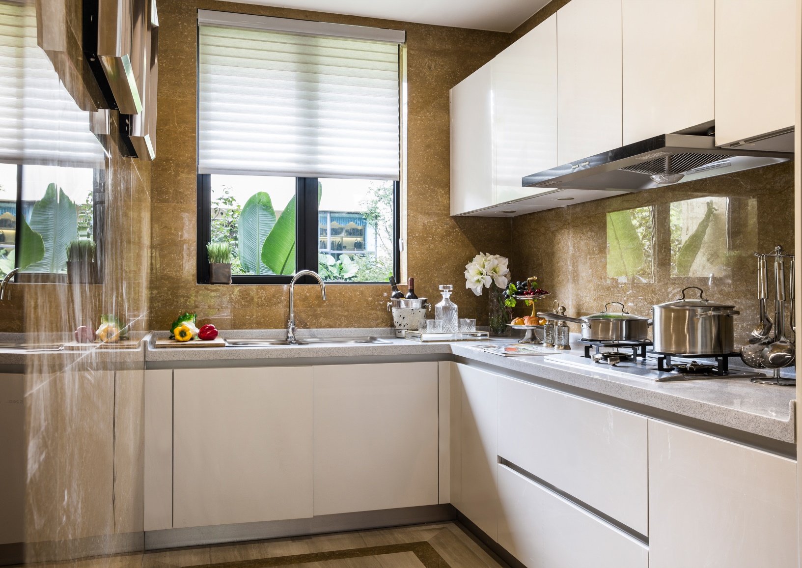 厨房大面积使用金色大理石铺贴，整体感轻奢雅致，白色橱柜尽显优雅。