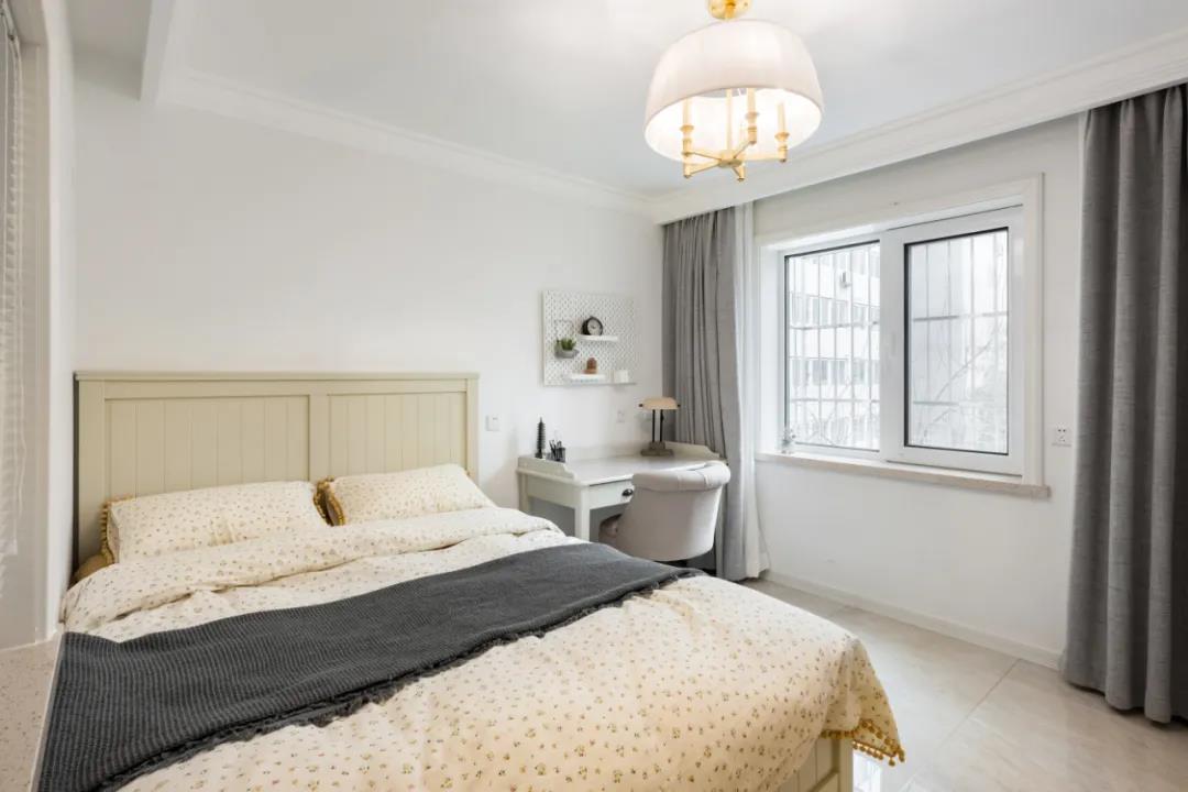 卧室以米色调为主，布置浅色木质床，以素色的床品布置，营造出简约优雅的卧室空间氛围。