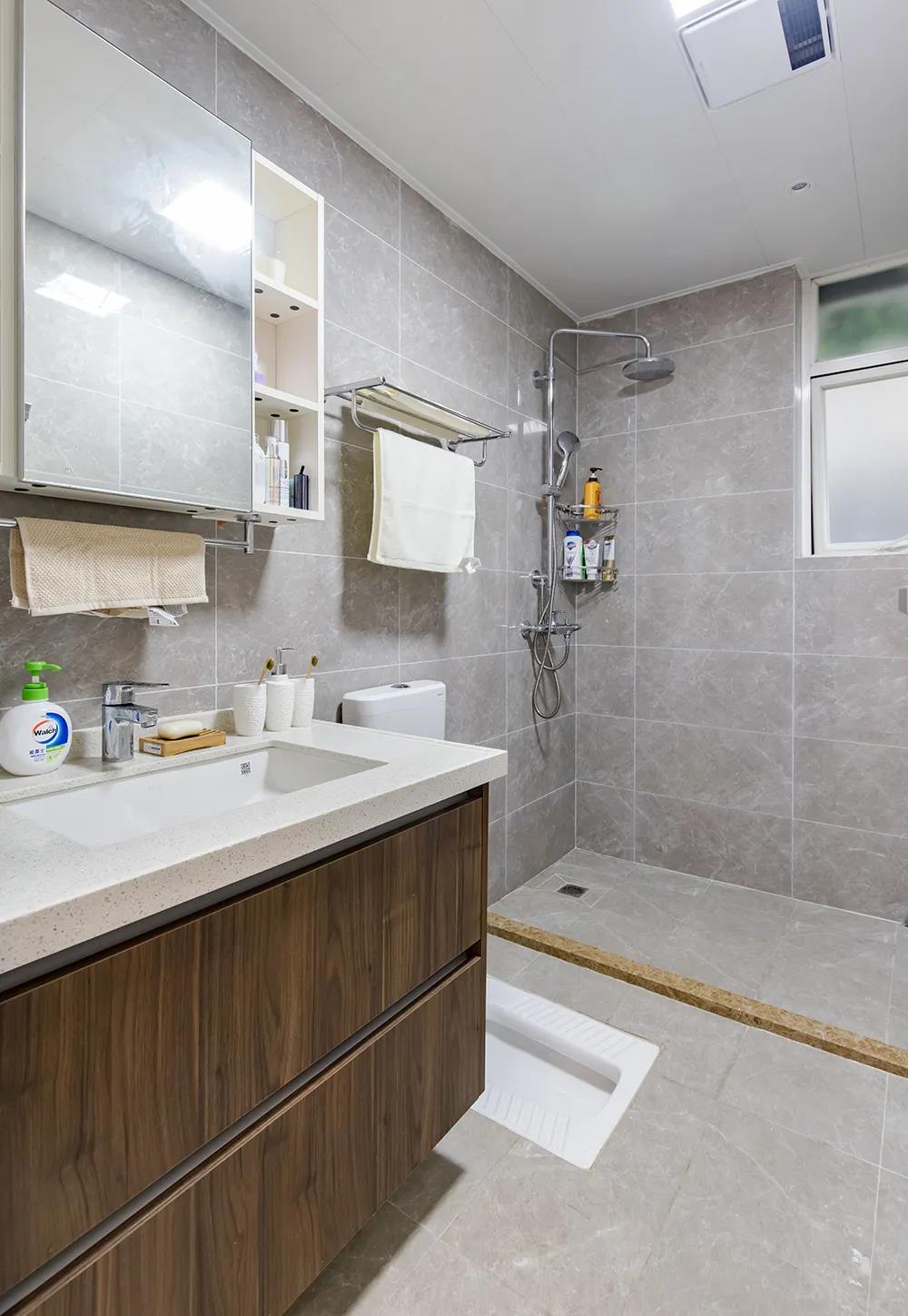 卫生间面积宽阔，实木材质的洗手柜设计，结合白色洁具，温雅的氛围油然而生。