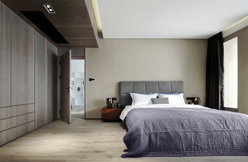 侧卧简约大气，背景墙没有任何装饰，米色背景墙下搭配灰色床头和紫色床品，现代感浓郁。