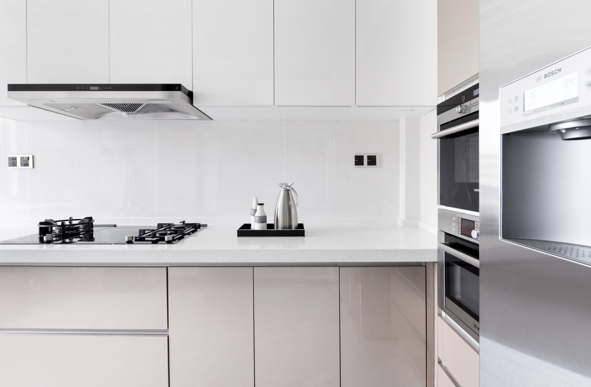 厨房的设计非常简单，白色吊柜搭配米色橱柜，功能便利实用，让空间更加活泼而富有生气。