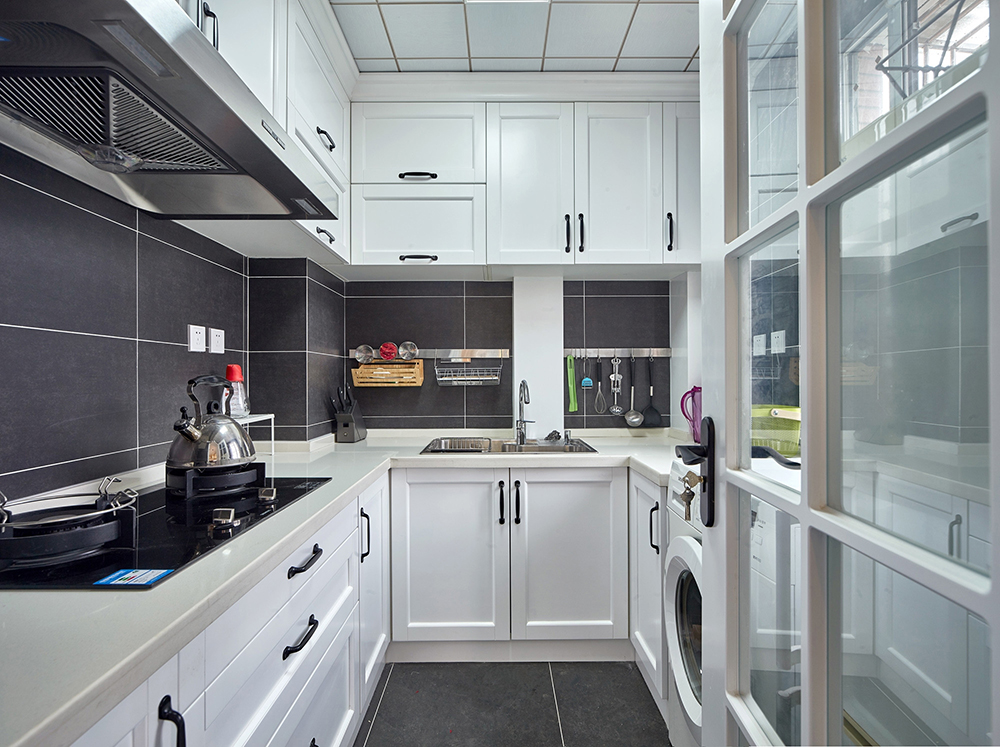 厨房采用定制式橱柜进行设计，白色橱柜质感与灰色背景相结合，显得十分简约。