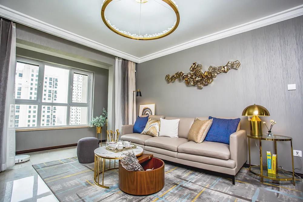 客厅米色地砖稳重又不失温馨，与深色背景墙形成对比，局部金色线条使空间更具现代时尚感。