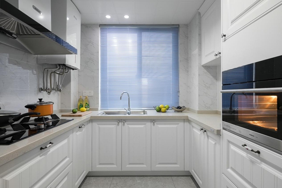 厨房干净优雅的色彩基调提升了明亮度，白色橱柜搭配米色调工作台，简洁自然而充满格调。