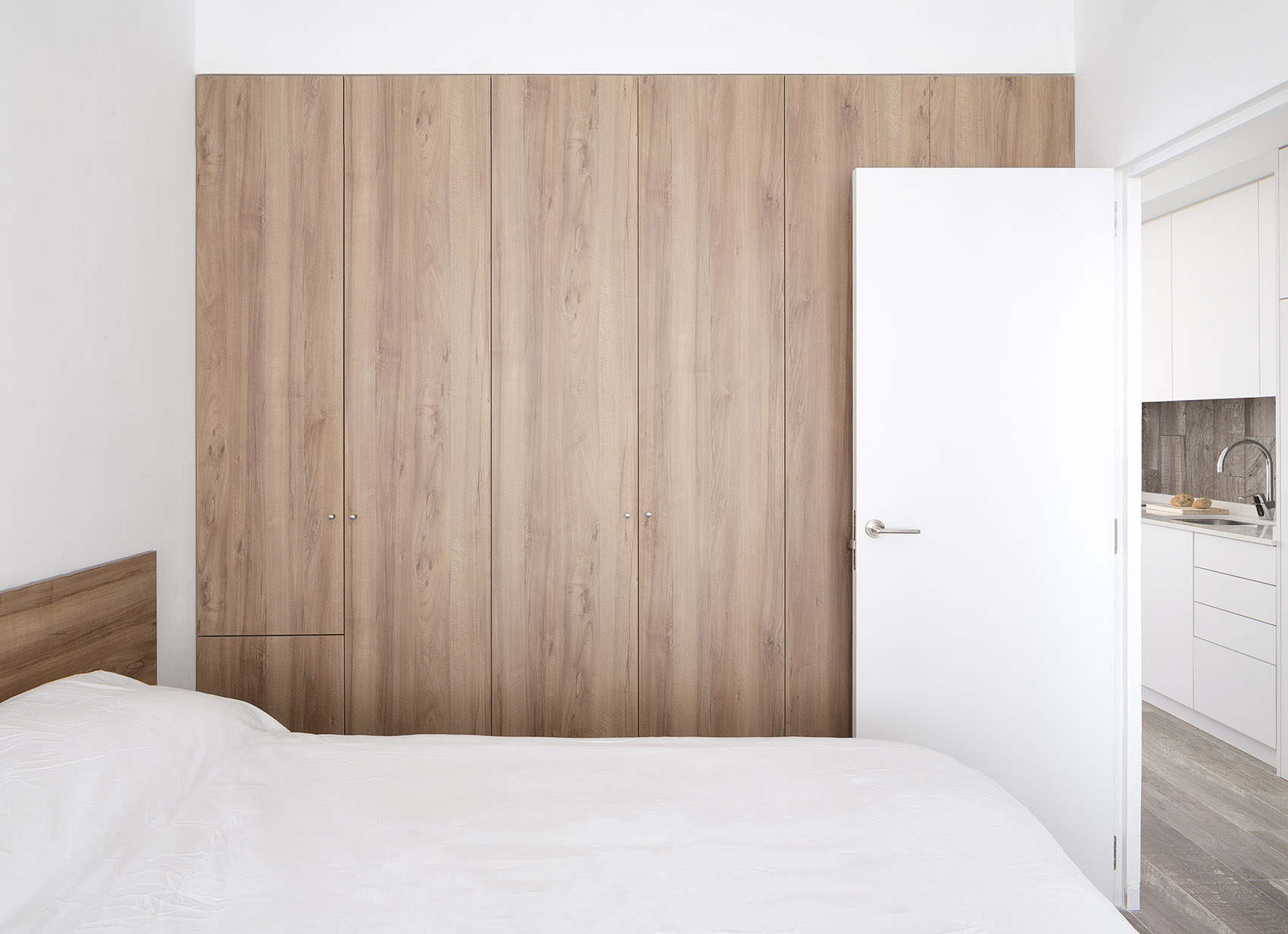侧卧使用白色和木色为基调，嵌入式木质衣柜的出现，很好的缓解了大面积白色带来的视觉疲劳。