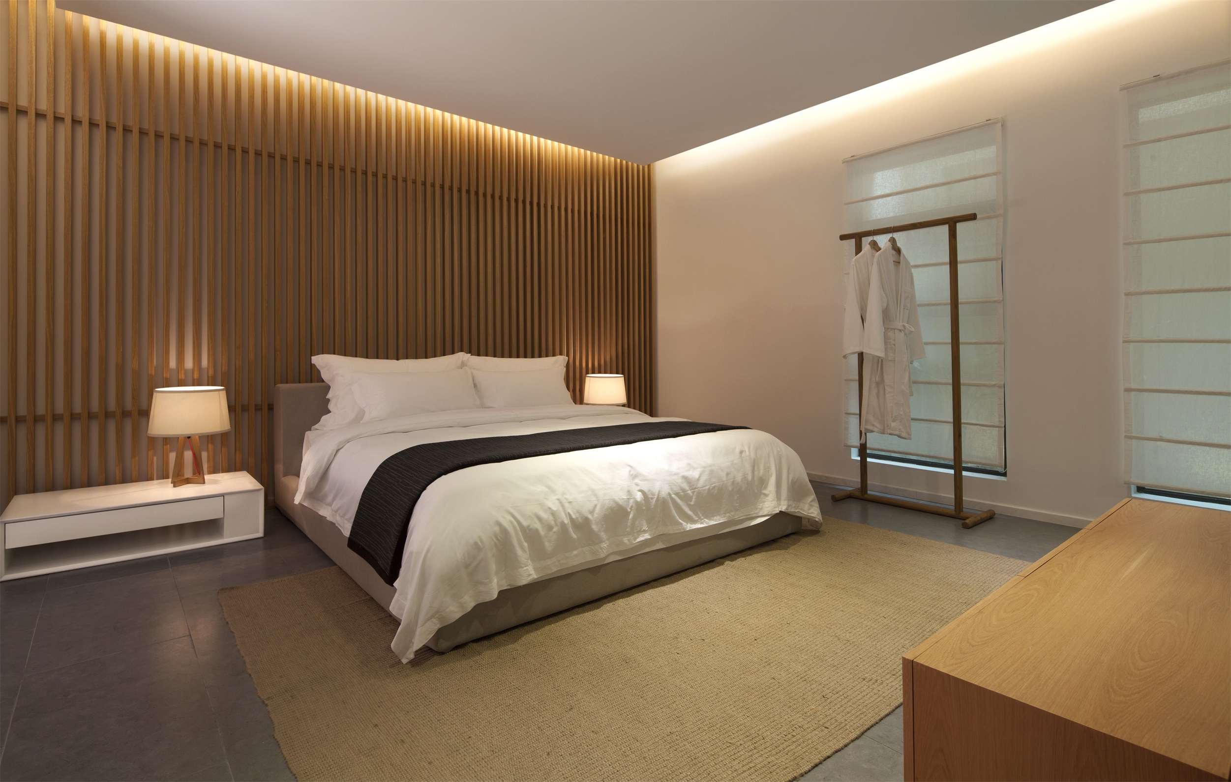 设计师利用木质元素组成背景，搭配白色床品，让房间充满温馨色彩。
