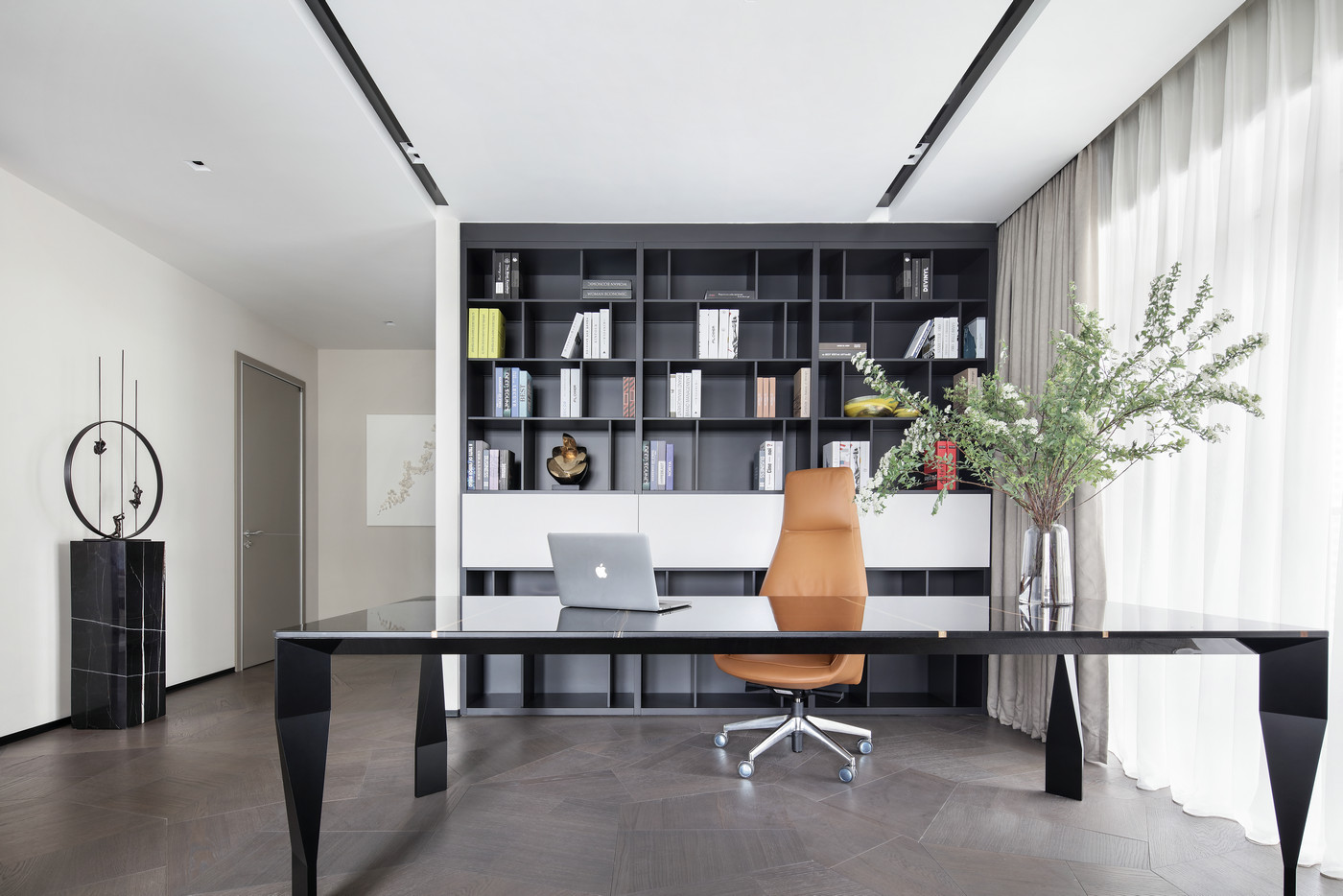 书柜黑白相间，黑色书桌大气优雅，局部使用焦糖色座椅点缀，令空间有了生机与活力。