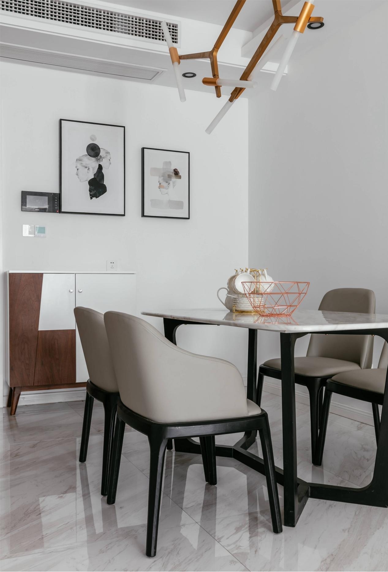 餐桌椅的材质与造型与客厅的相似，更加凸显整体风格。金属吊灯造型夸张张扬，使空旷的空间不显清冷。